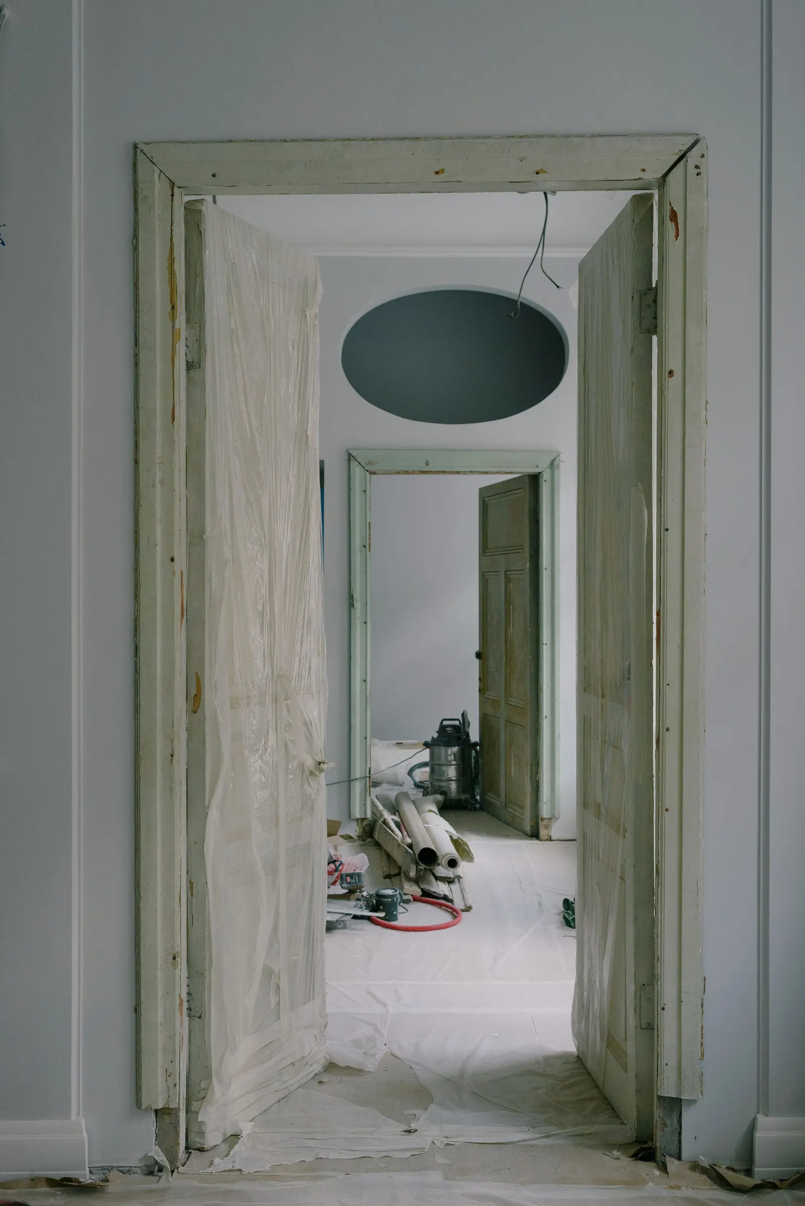 Interior de una vivienda en obra, con puertas y materiales apoyados en el suelo